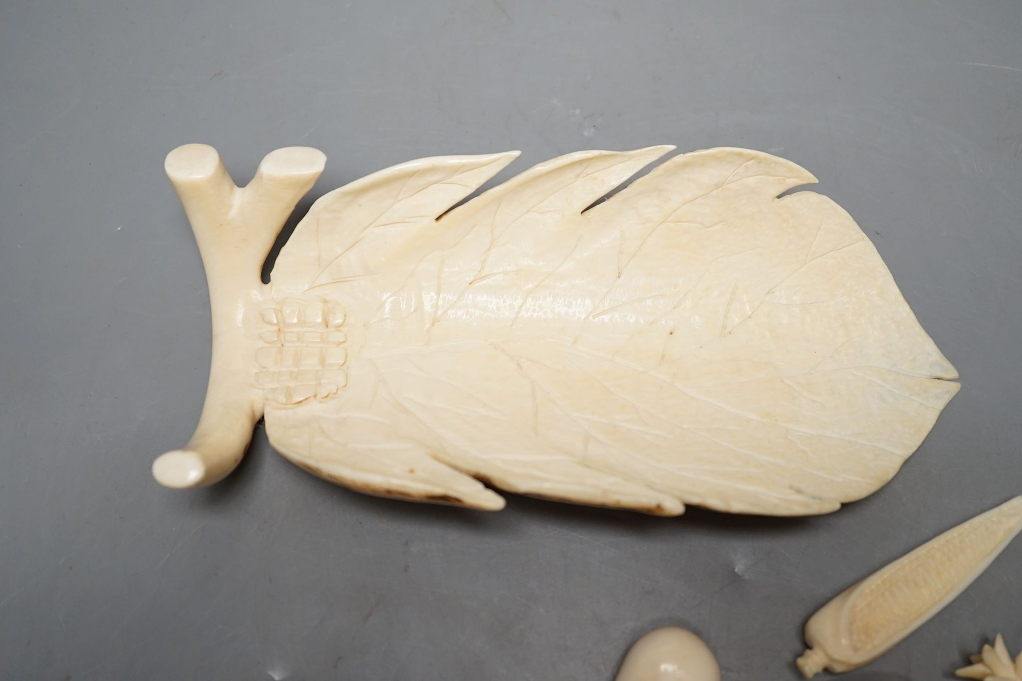 A group of Chinese carved ivory fruits, on ‘leaf’, 19cm